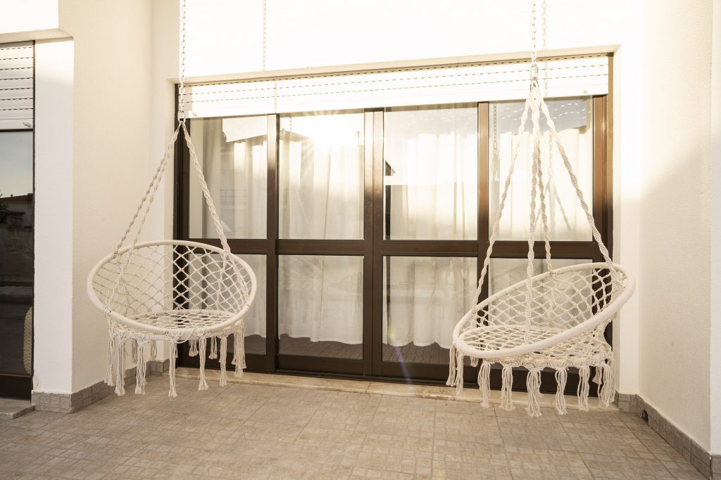Macrame Hanging Hammock seats in the sunny outdoor spaces at Ericeira Paradise Guest House Hotel and Suites in Portugal